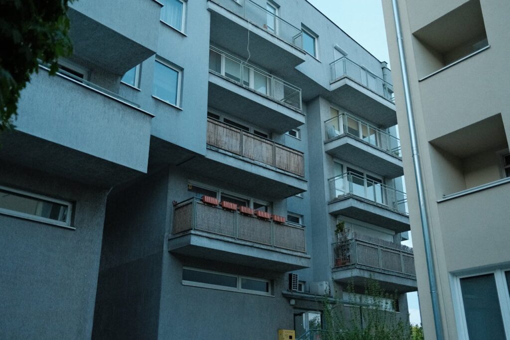 A contemporary residential building facade showcasing multiple balconies in an urban setting.